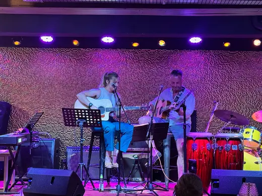 Acoustic guitars under purple stage lights