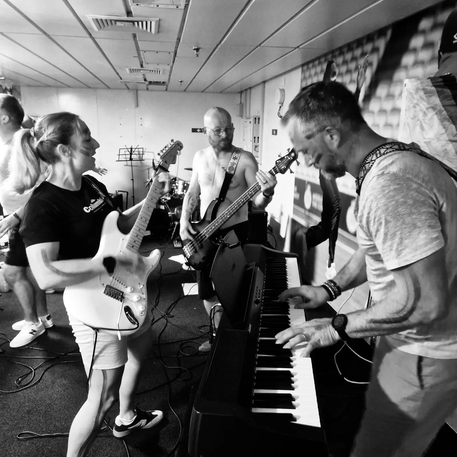 Guitar, bass and keys during a black-and-white rehearsal